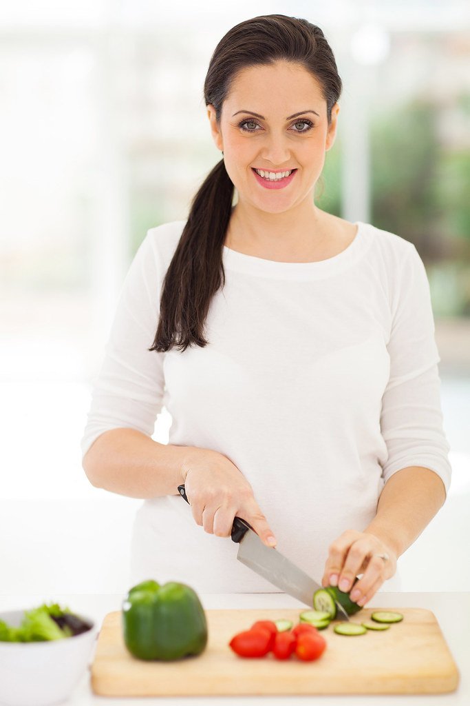 Mujer preparando una ensalada saludable en su cocina