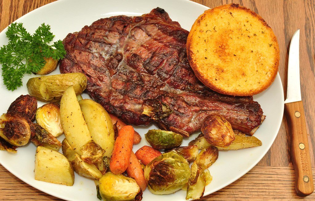 Bife de chorizo con guarnición de vegetales asados